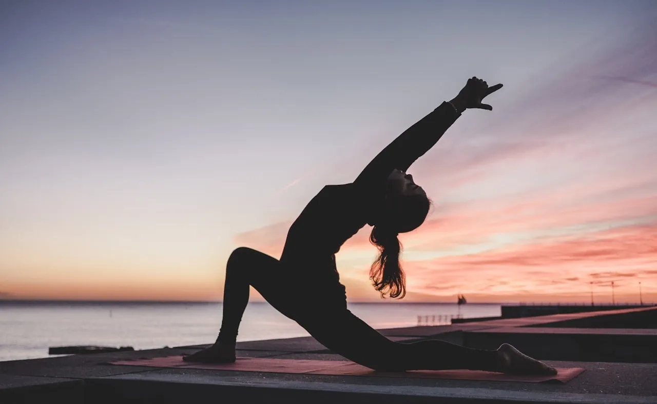 Silueta de una persona haciendo yoga al atardecer
